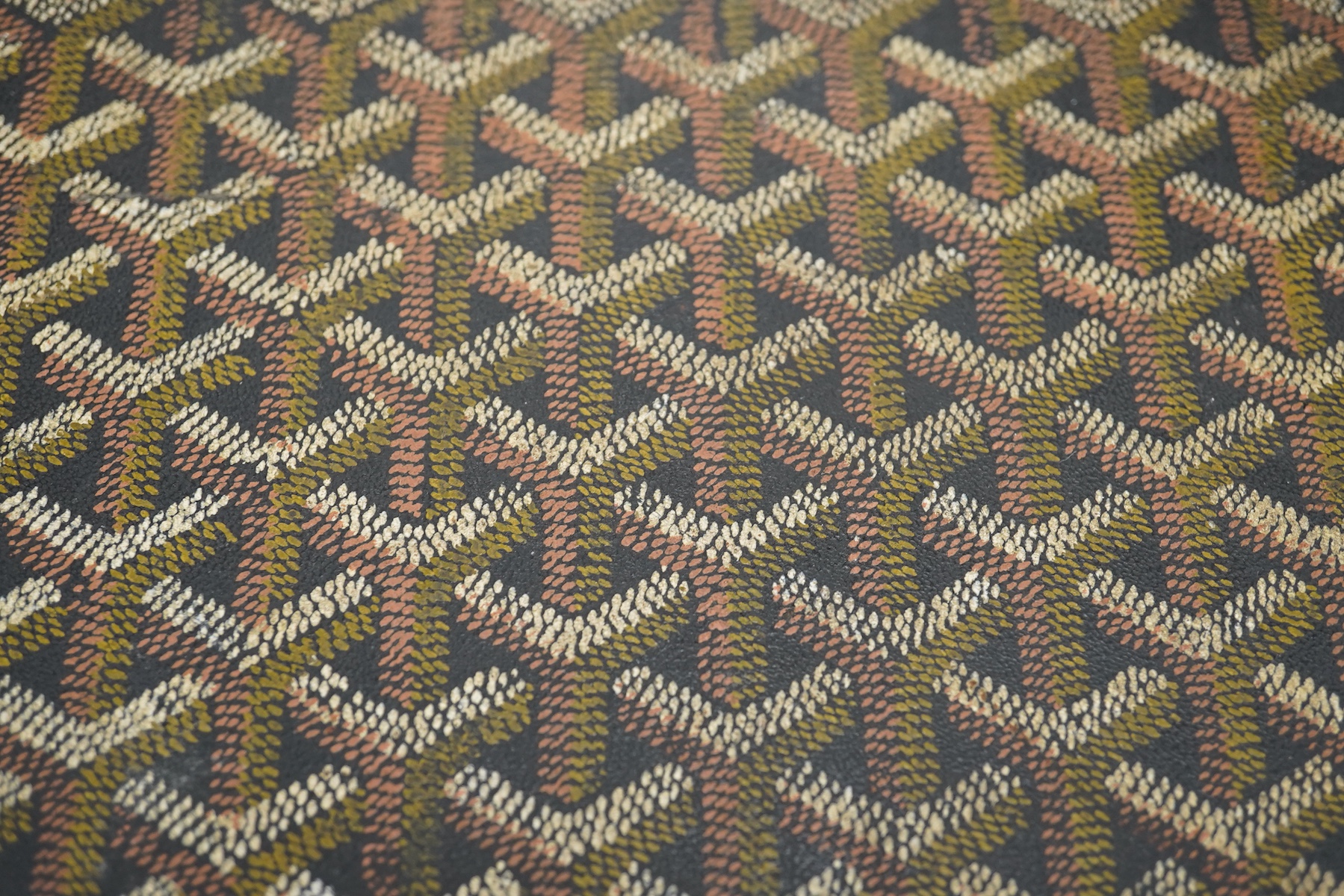 A vintage Malles Goyard suitcase with all over printed design, applied metal label to the exterior, height 13cm, width 49cm, depth 30cm